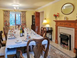 a dining room with a table and a fireplace at Holly Barn in Selattyn