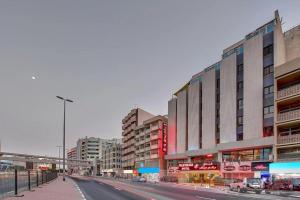 a city street with tall buildings and a road at Palm Beach Hotel in Dubai