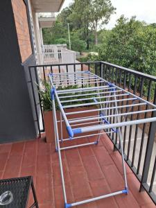 un banc en métal assis sur un porche dans l'établissement Dpto Resort zona aeropuerto, à Luque