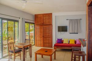 a living room with a couch with colorful pillows at Résidence Sarimanok in Nosy Be