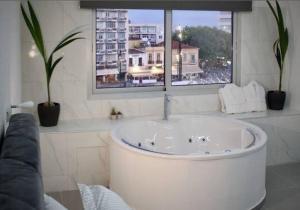 a white bath tub in a room with a window at Plateia Suite Deluxe in Nicosia +10 photos