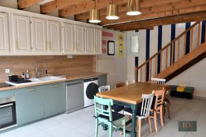 a kitchen with a table and chairs and a staircase at Le Gîte du Cerisier in Pouzauges