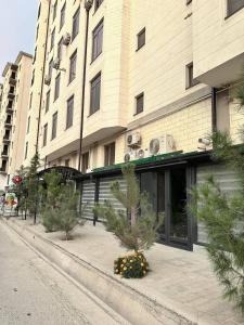 a building with trees and flowers in front of it at BEERloga in Samarkand