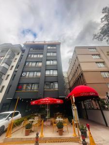 a building with tables and umbrellas in front of it at OTTO Boutique in Ankara