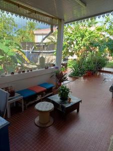 a porch with benches and tables on a patio at Chez Marino & Charlie in Le Lamentin