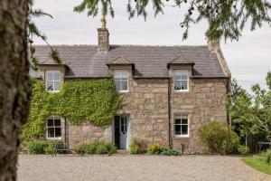 ein altes Steinhaus mit Efeu drauf in der Unterkunft Cailleachs Croft By Birch Stays in Stonehaven