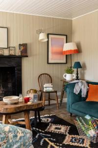 ein Wohnzimmer mit einem blauen Sofa und einem Tisch in der Unterkunft Cailleachs Croft By Birch Stays in Stonehaven