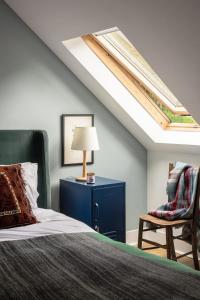 ein Schlafzimmer mit einem Bett, einer Lampe und einem Stuhl in der Unterkunft Cairn Cottage By Birch Stays in Stonehaven