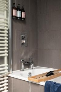 a bathroom with a bath tub with a sink at Burnside Cottage By Birch Stays in Stonehaven