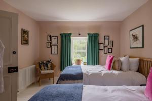 2 Betten in einem Schlafzimmer mit grünen Vorhängen in der Unterkunft Taigh A' Chiste By Birch Stays in Stonehaven