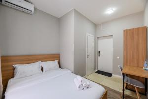 a bedroom with a bed and a desk with towels on it at Uide hotel in Almaty