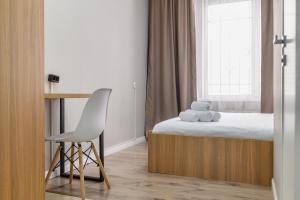 a small bedroom with a bed and a chair at Uide hotel in Almaty +19 photos