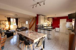 a kitchen and a living room with a wooden table at Gite de la route du blé in Alluyes