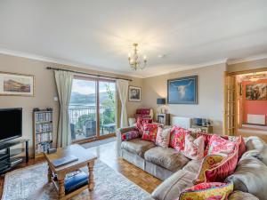 a living room with a couch and a tv at Lochside View in Lochearnhead