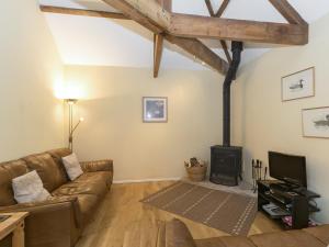 a living room with a couch and a stove at Westerdale Barn - 27944 in Battersby