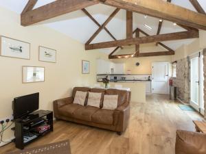 a living room with a couch and a kitchen at Westerdale Barn - 27944 in Battersby