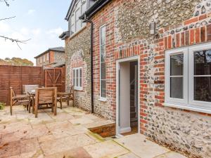 a patio with a table and chairs and a brick building at The Stables At Wells-In-The-Field Farm in Whitchurch