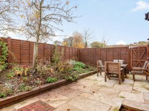 a patio with a fence and a table and chairs at The Stables At Wells-In-The-Field Farm in Whitchurch