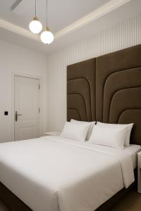 a bedroom with a large bed with white pillows at Hog Inn Hotel in Benin City