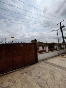 a fence in front of a building with power lines at Hog Inn Hotel in Benin City