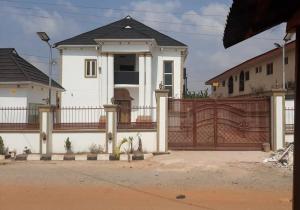 a white house with a gate and a fence at Hog Inn Hotel in Benin City