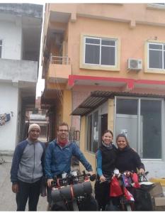a group of three people standing next to a motorcycle at Madhukunda Homestay in Butwāl