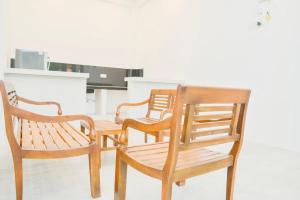three wooden chairs and a table and a chair at STARK Villa in Talpe