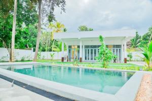 a swimming pool in front of a house at STARK Villa in Talpe
