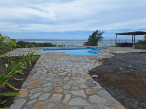 a stone walkway leading to a swimming pool at Belle étoile Gravier île Rodrigue in Saint Francois