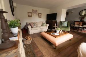 ein Wohnzimmer mit Sofa und Tisch in der Unterkunft Weavers Cottage in Stow on the Wold + 43 Fotos