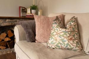 zwei Kissen auf einer Couch in einem Wohnzimmer in der Unterkunft Weavers Cottage in Stow on the Wold