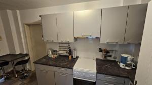 a kitchen with white cabinets and a counter top at Ferienwohnung Stephan in Berggiesshübel
