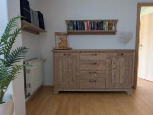 a wooden dresser in a room with a book shelf at Ferienwohnung Stephan in Berggiesshübel +2 photos