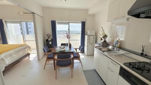 eine Küche mit Tisch und Stühlen und einem Bett in der Unterkunft SunSea Okinawa Stunning Ocean View 2BR Sleeps 6 20 min from Airport 3 min to Shopping Mall in Urazoe
