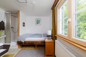 a bedroom with a bed and a window at Gasthaus Moosegg in Lochau