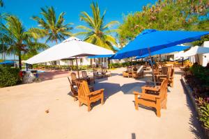 een groep stoelen en parasols op een strand bij Severini Villas Zanzibar in Nungwi
