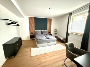 a bedroom with a bed and a desk and a chair at Modern Holiday Apartment in Osnabrück 13001 in Osnabrück