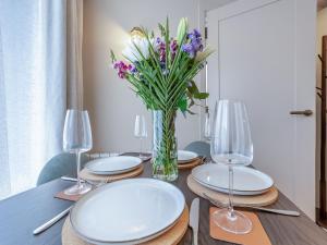 a table with plates and glasses and a vase of flowers at Sea Beet - Uk49245 in Whitstable
