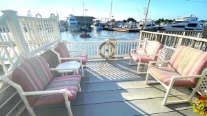 Un grupo de sillas en un porche cerca del agua. en Escape To Yacht - Upstairs Apartment, en Cape May