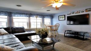 Una sala de estar con un sofá y un televisor de pantalla plana. en Escape To Yacht - Upstairs Apartment, en Cape May