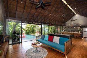 a living room with a blue couch and a pool at AN Village 1 in Vung Tau