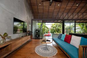 a living room with a blue couch and a tv at AN Village 1 in Vung Tau