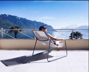 a woman sitting in a chair on a balcony at La Villa in Montreux