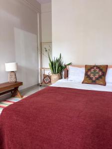 ein Schlafzimmer mit einem großen Bett mit einer roten Decke in der Unterkunft Drifters Surf Eat Stay in Kappil