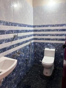 ein blau-weißes Bad mit einem WC und einem Waschbecken in der Unterkunft Drifters Surf Eat Stay in Kappil