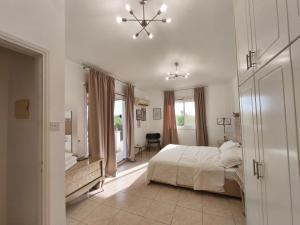 a bedroom with a bed and a dresser and a desk at Villa Arfa in Peyia +40 photos