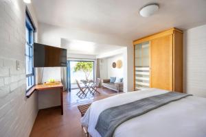 a bedroom with a bed and a tv in a room at Seehuis Studios in Langebaan