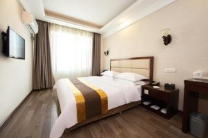 a hotel room with a large bed and a window at Chaogu Hotel in Changchun