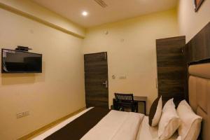 a bedroom with a bed and a tv on the wall at Hotel Blist villa in New Delhi