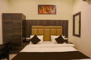 a bedroom with a large bed with a picture above it at Hotel Blist villa in New Delhi